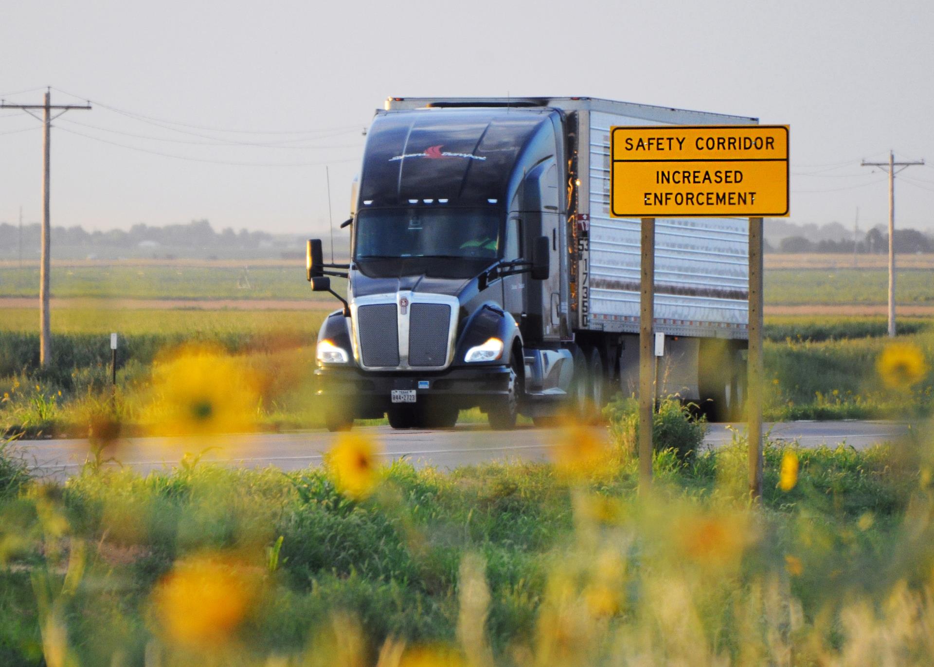 Semi-truck passing a safety corridor sign